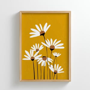 Può includere: Stampa artistica incorniciata con un'illustrazione stilizzata di margherite bianche con centri marroni e steli neri su sfondo giallo senape. L'opera d'arte è in una cornice di legno, adatta all'arredamento.