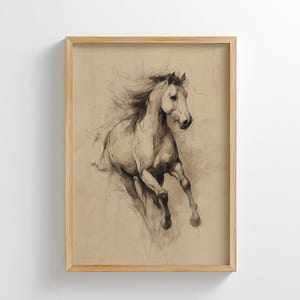 May include: A framed art print featuring a pencil sketch of a running horse. The horse is depicted in shades of gray and white against a tan background. The artwork is encased in a light brown wooden frame, suitable for home decor.