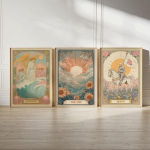 Puede incluir: Tres impresiones enmarcadas de cartas del tarot. La primera representa un ángel con alas doradas sobre una ola, con la etiqueta "JUDGEMENT". La segunda muestra un sol sobre girasoles, con la etiqueta "THE SUN". La tercera presenta un esqueleto a caballo, con la etiqueta "DEATH".