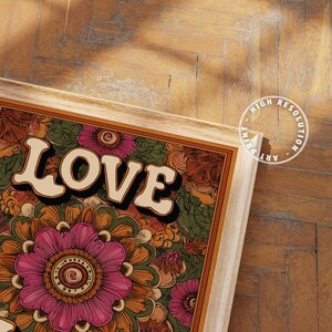 Puede incluir: Una impresi&oacute;n art&iacute;stica enmarcada con la palabra "LOVE" en una fuente retro. La obra de arte presenta un dise&ntilde;o floral en tonos de rosa, naranja y verde. El marco es de color madera clara y la impresi&oacute;n est&aacute; etiquetada como "HIGH RESOLUTION ART PRINT."