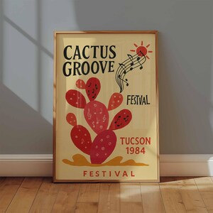 K&ouml;nnte beinhalten: Gerahmtes Poster mit beigem Hintergrund, das eine rote Kaktus-Illustration mit Noten zeigt. Der Text "CACTUS GROOVE FESTIVAL TUCSON 1984" ist in Schwarz und Rot dargestellt. Eine Sonnengrafik und Noten sind ebenfalls enthalten.