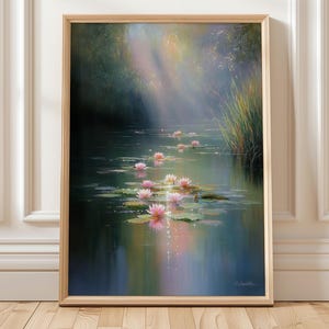 Può includere: Dipinto incorniciato raffigurante una serena scena di stagno. Ninfee rosa galleggiano sulla superficie dell'acqua, riflettendo la luce del sole che filtra attraverso gli alberi. L'opera d'arte è racchiusa in una cornice di legno marrone chiaro.