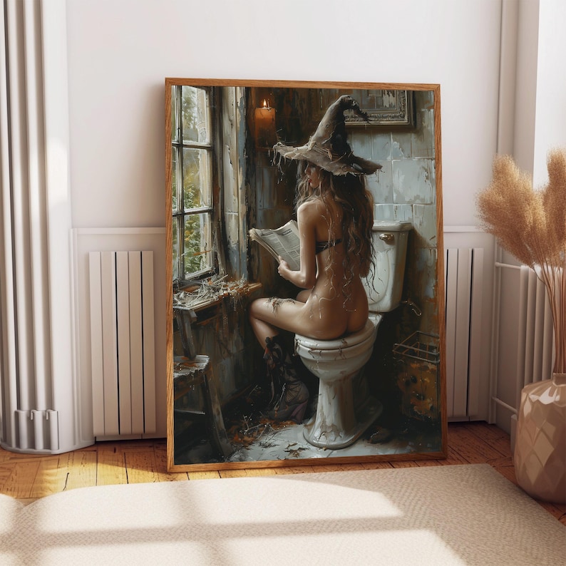 May include: A framed art print showing a person wearing a witch hat, seated on a toilet, reading a newspaper. The artwork has a vintage aesthetic with a muted colour palette, featuring a window and a lit candle.