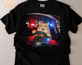May include: Black t-shirt with a graphic of an orange cat driving a car, with police lights flashing. The cat has a surprised expression. The word "BLACK" is in a circle in the upper left corner.