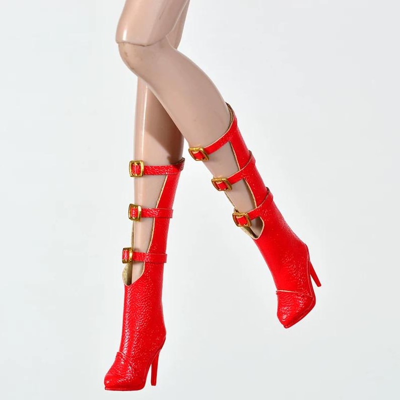 May include: Red high-heeled boots with gold-colored buckles. The boots have a textured appearance and feature multiple straps and a pointed toe. The heels are slender and the boots appear to be made of a shiny material.