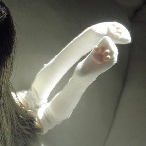 May include: A white ceramic mug with a black handle and the text "But First, Coffee" in a black, bold font. The mug is on a white surface.