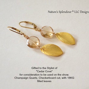 May include: Gold earrings with champagne quartz stones and gold leaf accents. The earrings are designed with a checkerboard cut and 18 karat gold filled leaves. The earrings are gifted to the stylist of "Cedar Cove".
