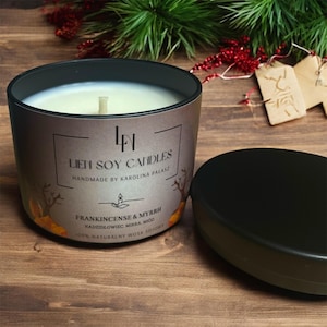 Puede incluir: Una vela de soja marrón y negra con una tapa negra. La vela está etiquetada con "Frankincense & Myrrh" y "Lien Soy Candles Handmade by Karolina Palasz". La vela está rodeada de hojas de otoño.
