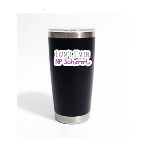 May include: A black stainless steel tumbler with a white sticker that says "I can't, I'm in NP School" in black and purple text.