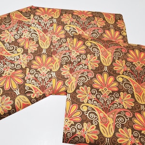 May include: Four sheets of brown wrapping paper with a gold and orange paisley pattern.