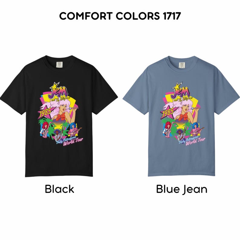 May include: Two short-sleeve t-shirts, one black and one blue jean, featuring the text COMFORT COLORS 1717 at the top. The graphic displays the Jem and the Holograms logo, the year 1985, and the text Truly Outrageous World Tour with colorful band members.