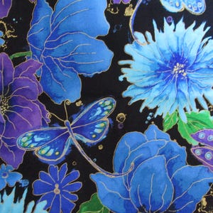 May include: A fabric with a floral pattern featuring large blue and purple flowers, dragonflies, and smaller blue blossoms against a black background. Gold accents highlight the details of the flowers and insects.