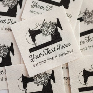 Peut inclure: Un ensemble d'&eacute;tiquettes en tissu blanc avec une machine &agrave; coudre noire et un motif floral. Les &eacute;tiquettes sont personnalisables avec le texte "Your Text Here" et une deuxi&egrave;me ligne de texte.