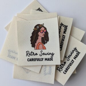 May include: A stack of white fabric labels with a retro-style illustration of a woman wearing sunglasses and a flower crown. The text on the label reads "Retro Sewing Carefully Made".