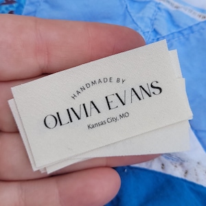 May include: Handmade by Olivia Evans, a white fabric label with black text. The label says "Handmade by Olivia Evans, Kansas City, MO".