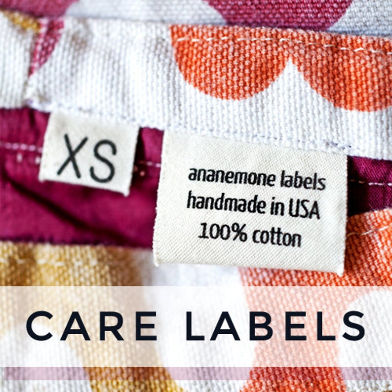 Op de afbeelding: Verzorgingsetiketten voor een kledingstuk, met een witte achtergrond en kleurrijke stippen. De etiketten zijn wit met zwarte tekst. De tekst op de etiketten luidt "anemone labels handmade in USA 100% cotton" en "XS".