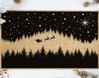 May include: A rectangular doormat with a black and gold Christmas scene. The design features a silhouette of a forest, Santa's sleigh with reindeer, stars, and a large star. The mat is surrounded by a gold border.