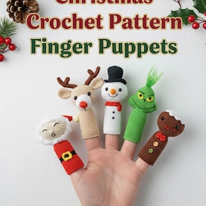 May include: A hand displays five colorful crochet finger puppets: Santa, a reindeer, a snowman, the Grinch, and a gingerbread man. The puppets are made with yarn and feature festive details. Text at the top reads "Christmas Crochet Pattern Finger Puppets."