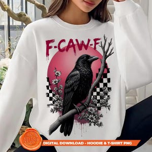 Puede incluir: Sudadera blanca con un diseño de un cuervo negro posado en una rama, sobre un círculo rosa y un fondo a cuadros. El texto "F-CAW-F" está encima del cuervo. El diseño incluye detalles florales y el texto "DIGITAL DOWNLOAD - HOODIE & T-SHIRT PNG".