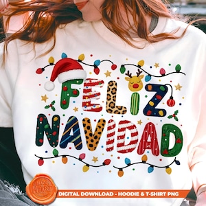 May include: A cream-coloured sweatshirt featuring the words "FELIZ NAVIDAD" in vibrant, festive lettering. The design incorporates a Santa hat, reindeer, string lights, and stars, ideal for the holiday season. The text "DIGITAL DOWNLOAD - HOODIE & T-SHIRT PNG" is also visible.