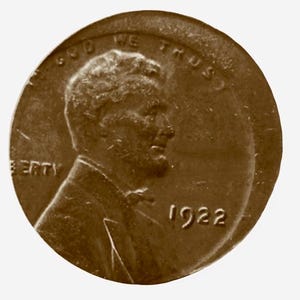 May include: A copper-colored US penny with the inscription "IN GOD WE TRUST" and "LIBERTY" on the obverse. The year "1922" is inscribed on the reverse.