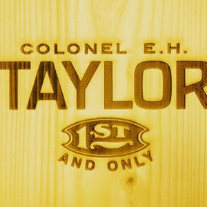 May include: A wooden sign with the text "Colonel E.H. Taylor 1st and Only" in a vintage style font.