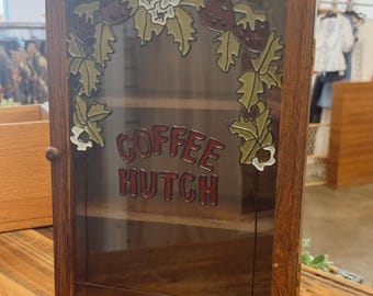 Aparador de café antiguo de madera con vidrieras y diseño floral de fresas.