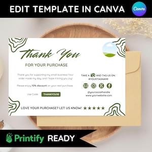 May include: A white and green thank you card with the text "Thank You For Your Purchase". The card includes a 10% discount offer and social media handles. The card is placed on a wooden plate with a beige envelope.