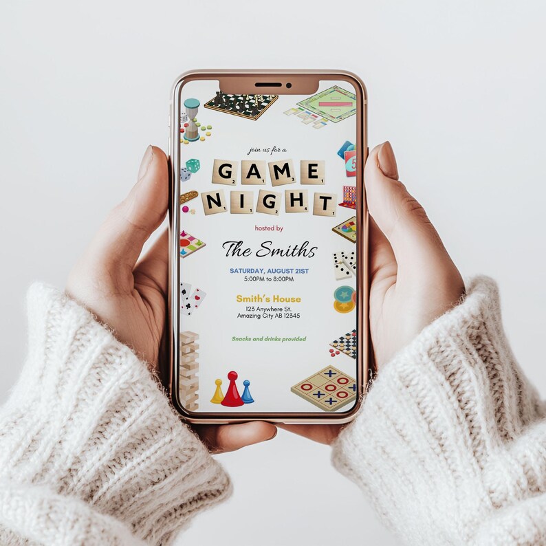 May include: A smartphone displays a game night invitation. The invitation features the words "GAME NIGHT" in Scrabble tiles, hosted by "The Smiths." Various game pieces and graphics surround the text, including dice, cards, and board games. The date and time are also included.