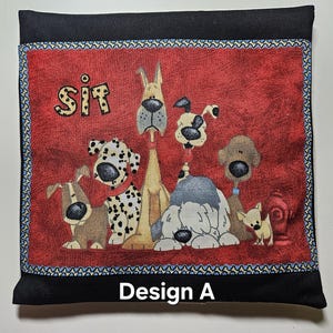 May include: A black square pillow with a red center featuring cartoon dogs. The word "SIT" is above the dogs. The pillow has a blue and white patterned border and the text "Design A" at the bottom.