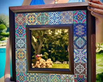 May include: A wooden framed mirror with a decorative border of colorful patterned tiles. The tiles are in shades of blue, green, yellow, red, and brown.