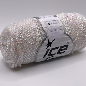 Puede incluir: Ovillo de hilo blanco crema con hilos metálicos iridiscentes. La etiqueta dice "Fine" e "ICE". El hilo es de peso medio, 50g, y unos 251 metros. Ideal para proyectos de punto y ganchillo.
