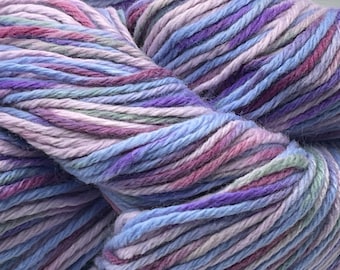 May include: A skein of yarn in a multi-colored pattern of blue, purple, pink, and green. The yarn is soft and fluffy, and it would be perfect for knitting or crocheting.