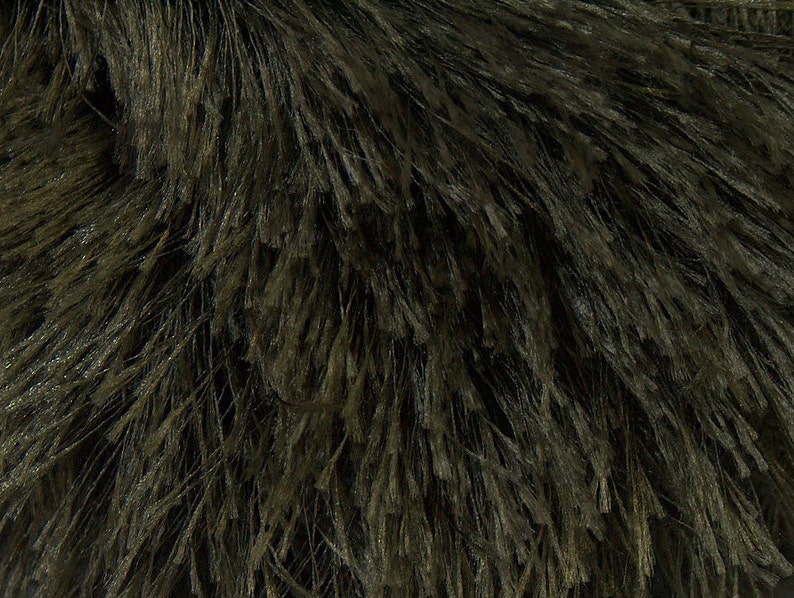May include: Close-up of a dark green fuzzy fabric with a soft, plush texture.
