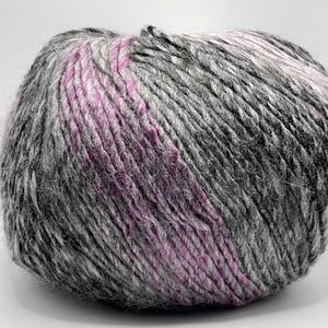 May include: A ball of yarn in shades of gray, black, and pink. The yarn has a textured appearance, with visible strands and a soft, fluffy quality. The pink color is concentrated in a stripe across the ball. Ideal for knitting and crochet projects.
