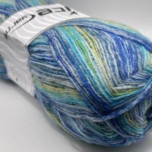 May include: A close-up of a skein of yarn in shades of blue, teal, and yellow. The yarn is wrapped with a white label that reads "asice yarn". The yarn is tightly wound and appears soft.