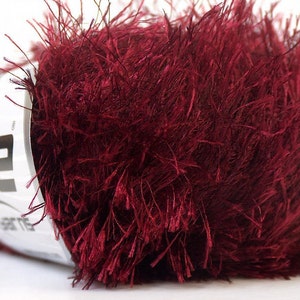 May include: A skein of burgundy red fuzzy yarn with a white label that says "Ice Garn".