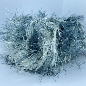 May include: A skein of blue and white yarn with a fuzzy texture.