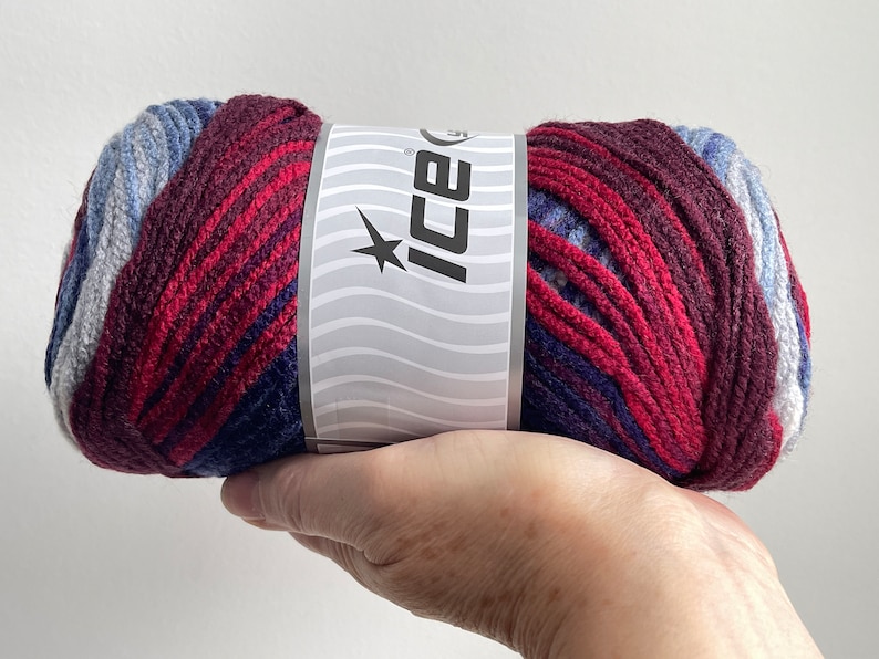 May include: A skein of red, blue, and gray yarn with a white label that says "Ice" with a star on it.