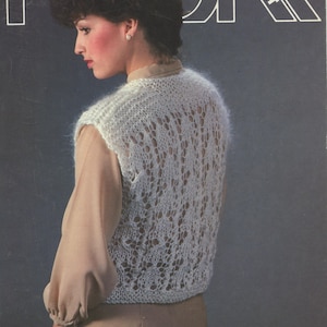 May include: A vintage image of a woman wearing a white, open-weave knitted vest. The vest has a delicate, lacy pattern. The background is a dark blue with the word "DAR" and the word "LEAFLET" in white.