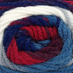 May include: A skein of yarn with a multi-colored pattern of white, gray, blue, red, and purple.