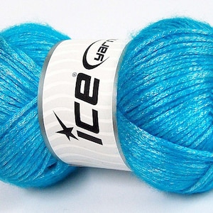 May include: A skein of turquoise blue yarn with silver glitter threads. The yarn is wrapped around a white label with the word "ICE" in black letters and a star.