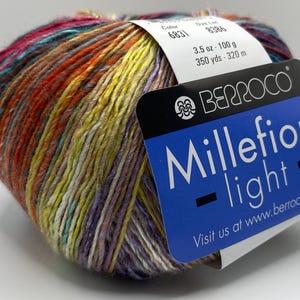 May include: A vibrant ball of Berroco Millefiori Light yarn, featuring a mix of colours like red, yellow, purple, and teal. The label states "Millefiori light" and includes the weight of 100 g and 320 m.