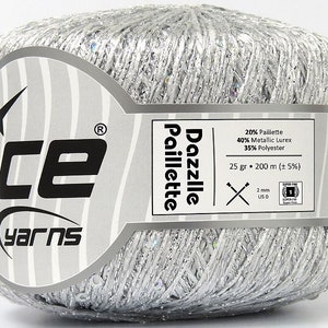 May include: A silver ball of yarn with sequins, labeled "Dazzlle Paillette" and "Ice Yarns". The label also lists the yarn composition: 20% Paillette, 40% Metallic Lurex, 35% Polyester. The yarn is 25 grams and 200 meters long.