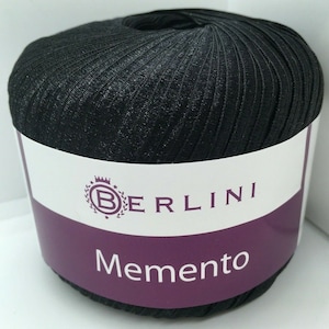 May include: A black ball of yarn with a white label that says "BERLINI Memento".