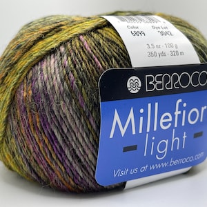 May include: A ball of Berroco Millefiori light yarn in a mix of colours including green, purple, and orange. The label indicates 100 g and 320 m. The label also includes the text "Millefiori light".