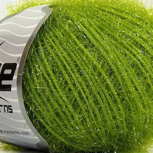 May include: A skein of green yarn with a silver label that says "Ice Yarns" and a star logo. The yarn has a fuzzy texture and a subtle shimmer.