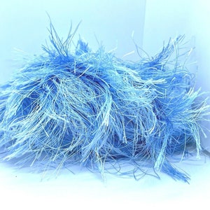 May include: A bundle of light blue and white fluffy yarn. The yarn is soft and textured, perfect for knitting or crocheting.