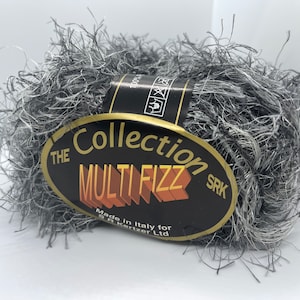 Peut inclure: Une pelote de fil gris et blanc duveteux avec une étiquette qui indique "The Collection Multi Fizz SRK Made in Italy for S.R. Kerzer Ltd."