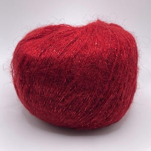 May include: A ball of red yarn with metallic threads. The yarn has a soft, fuzzy texture and is suitable for knitting or crocheting projects. The yarn is a deep, rich red color.